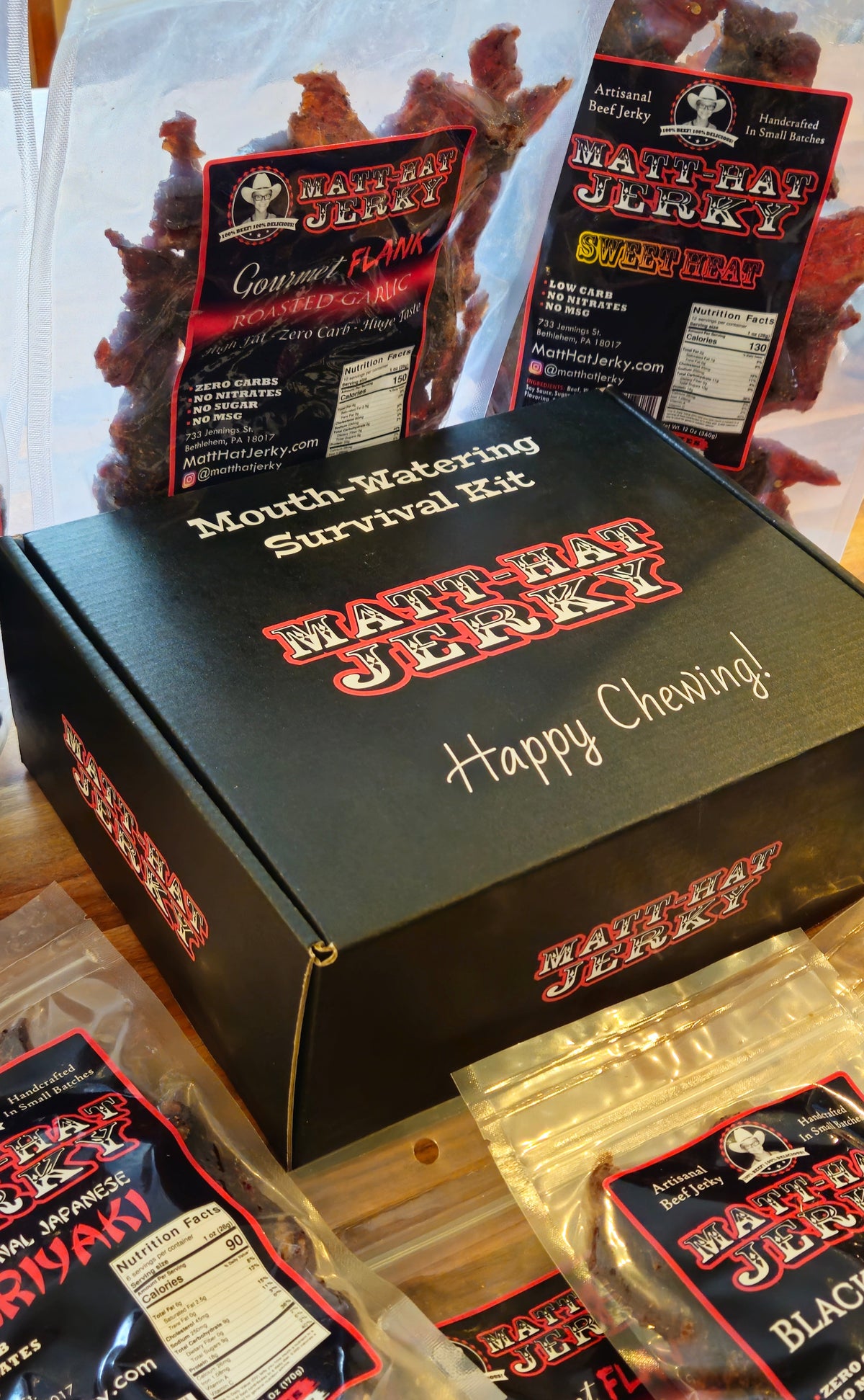 Scary Good Beef Jerky Gift Box (10 bags): Matt-Hat Jerky gift box shown at an angle with bags of beef jerky